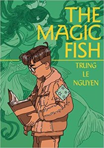 The Magic Fish by Trung le Nguyen cover shows a boy with glasses and a patched jacket looking at an open book. In the background is an illustration of a mermaid.