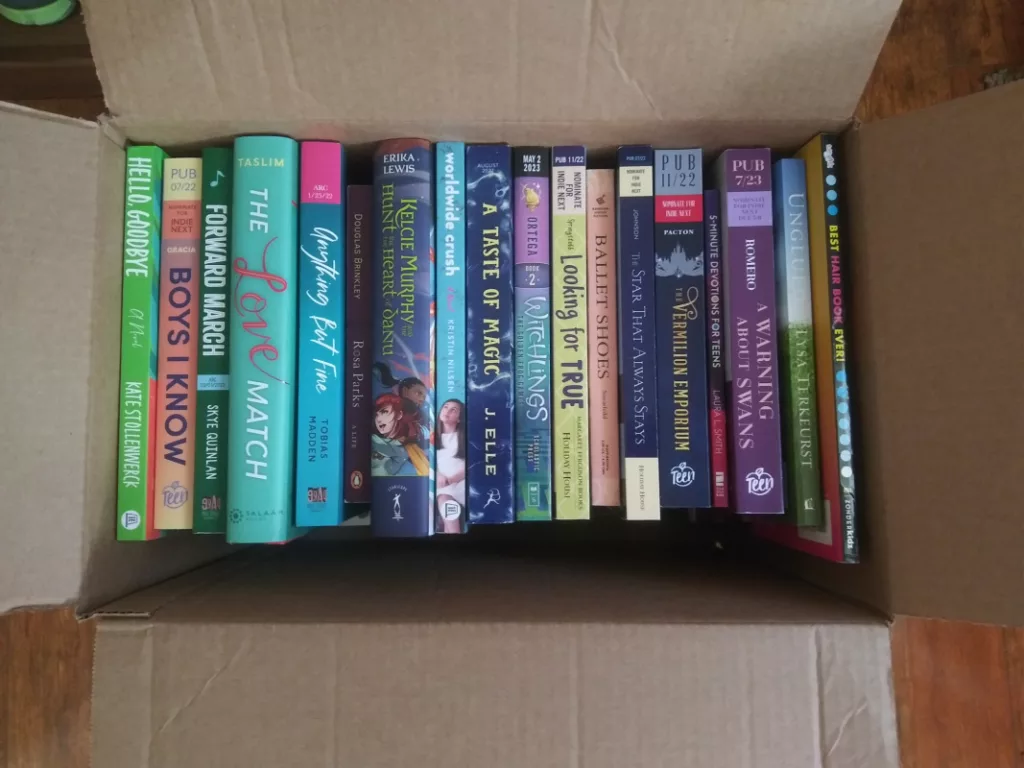 Books donated to a facility in Alabama. Photo shows a cardboard box filled with YA and MG books, spines showing.