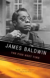 The Fire Next Time by James Baldwin cover shows a Black man with serious expression looking up and off to one side, a building in the background behind him.